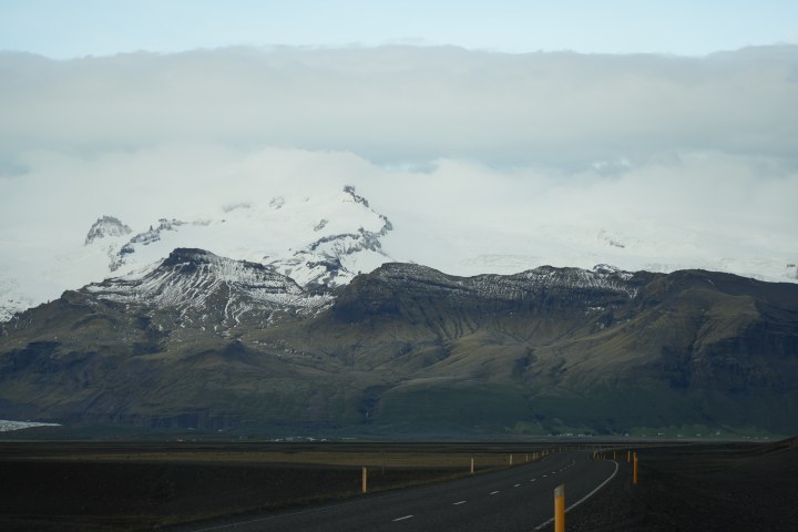 A winding road leading toward distant snow-covered peaks